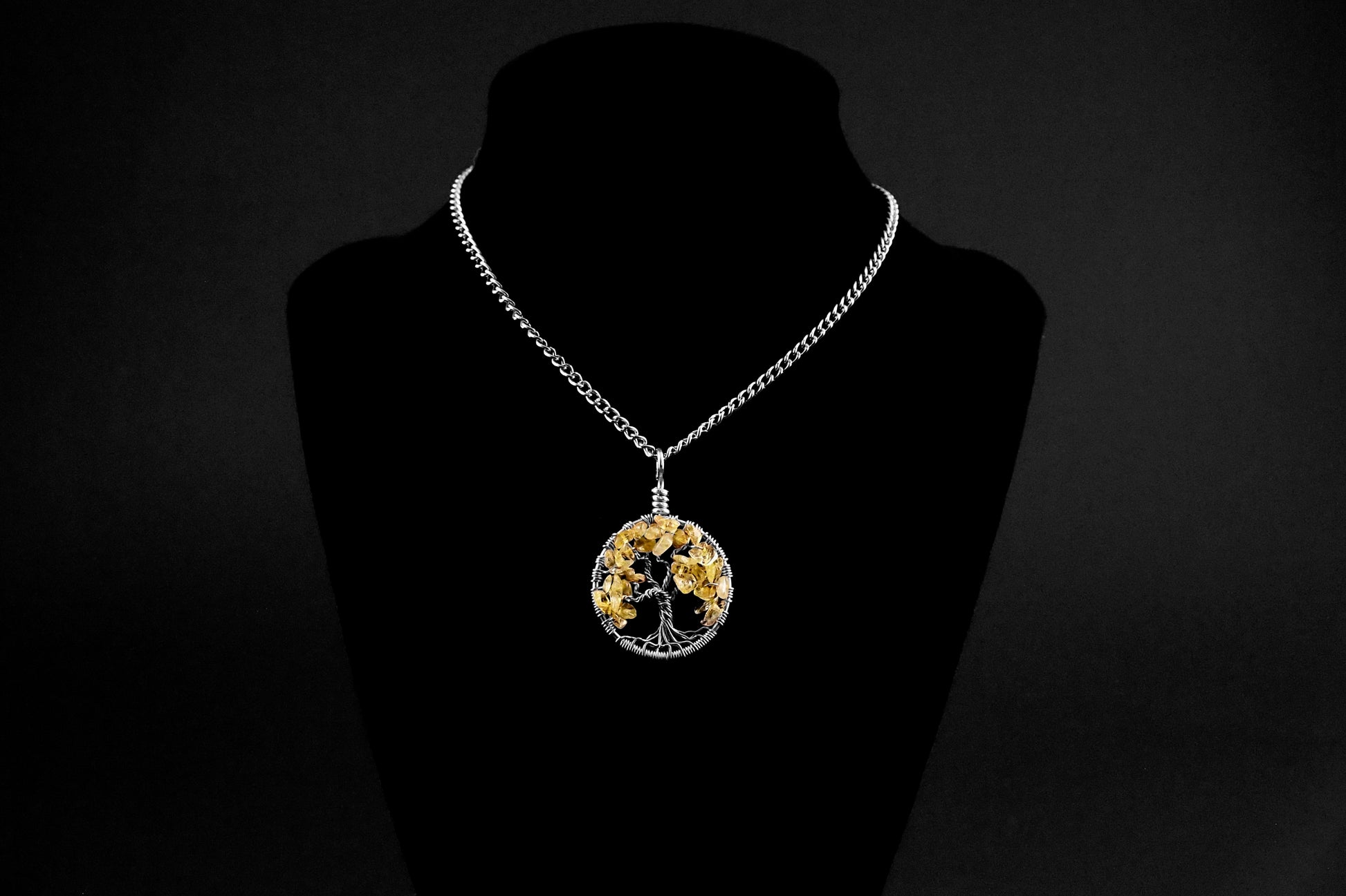 An image of the November birthstone tree of life pendant from Uncorked & Bottled Up on a mannequin to show how the necklace is worn. Made with genuine citrine gemstones and sterling silver wire