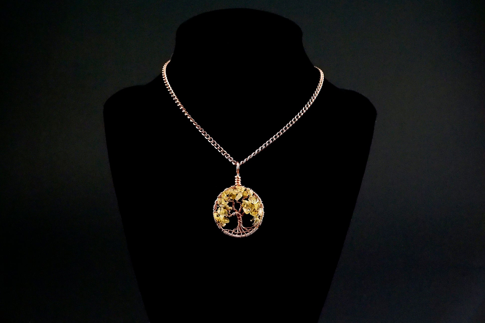 An image of the November birthstone tree of life pendant from Uncorked & Bottled Up on a mannequin to show how the necklace is worn. Made with genuine citrine gemstones and copper wire